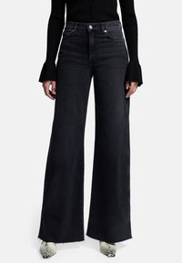 Jeans in denim neri a vita alta e gamba larga con orlo sfilacciato, chiusura con bottone e tasche laterali. Tessuto liscio e vestibilità strutturata.