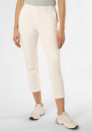 Pantaloni cropped beige chiaro realizzati in tessuto elasticizzato, caratterizzati da una vestibilità slim e tasche laterali, abbinati a sneakers sportive di colore chiaro.