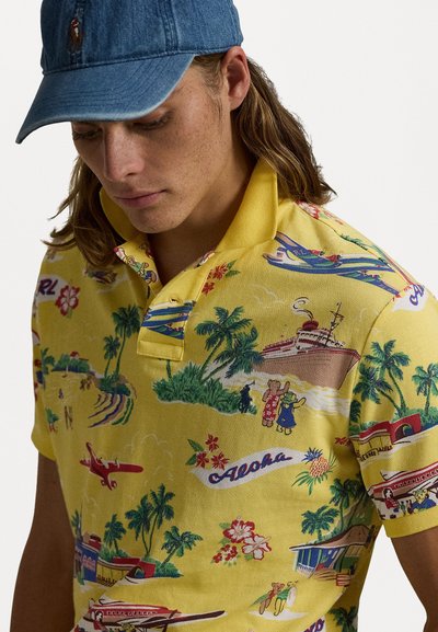 Camisa polo amarilla con estampado tropical que incluye palmeras, playas y barcos vintage. Diseñada con un cuello tipo polo y una tela texturizada.