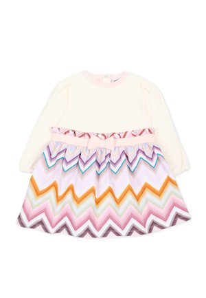 Crèmekleurige jurk met lange mouwen, een multicolour zigzag-patroon rok en een roze strik op de tailleband voor een peutermeisje.