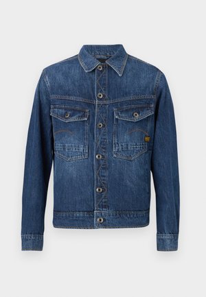 Dark blue denim jacket with button closure, two flap chest pockets, and contrast stitching on a plain light background.