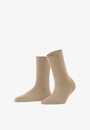 Chaussettes beiges avec texture côtelée, de longueur moyenne, avec un renfort à l'orteil et au talon, et une finition lisse. Conçues pour le confort et la durabilité.