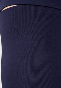 Leggings blu navy realizzati in un tessuto elasticizzato con un motivo a costine texturizzato e un dettaglio a taglio in vita, che offrono un design aderente.