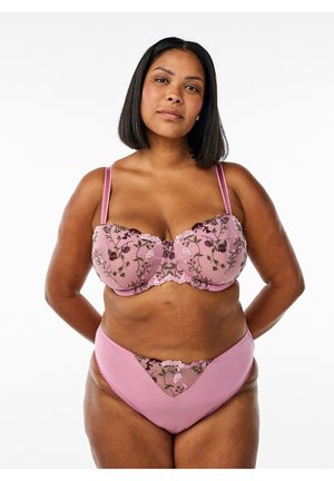 Set di lingerie rosa con reggiseno balconette decorato con ricami floreali, spalline regolabili e mutandine alte abbinate con dettagli trasparenti.