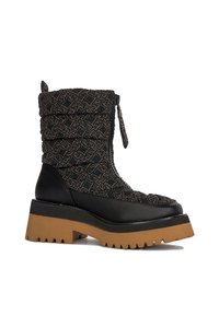 Czarne pikowane botki za kostkę z wzorzystą tkaniną u góry i gładką czarną skórą na dole. Gruba kauczukowa podeszwa z brązowym bieżnikiem. Zamek błyskawiczny po boku.