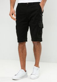 Schwarze Cargo-Shorts mit lässiger Passform, ausgestattet mit Seitentaschen und einem Knopfverschluss. Hergestellt aus weichem Stoff mit glatter Textur.