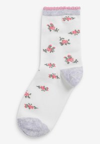 Weiße Knöchelstrümpfe mit pinkem Blumenmuster, lila Zehen und Bündchen sowie gewelltem pinkem Saum. Weiches Strickmaterial.