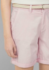 Bermuda rosa chiaro in cotone con orli arrotolati, tasche frontali e una cintura intrecciata color crema. Tessuto morbido con dettagli di cucitura discreti.