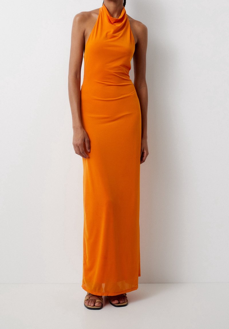 Robe longue orange sans manches avec un col licou, fabriquée en tissu lisse, présentant une silhouette ajustée et un ourlet droit.