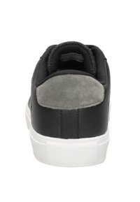 Zwarte sneaker met grijze suède hieltab, een getextureerde stoftong en een witte rubberen zool. Eenvoudig, lage ontwerp met minimale accenten.