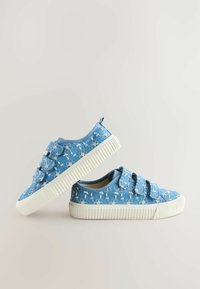 Baskets en toile bleue avec broderie florale, deux sangles à velcro, semelle en caoutchouc blanche, bout rond et détails de design texturé.