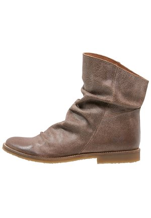 Bottine en cuir marron au design décontracté, bout rond, semelle plate en caoutchouc, avec des détails de couture latéraux sur fond blanc.