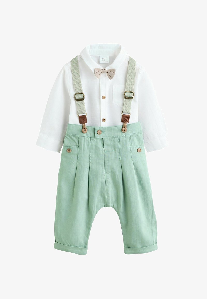 Camisa blanca de manga larga con botones de madera y pajarita, combinada con pantalones verde menta con tirantes y detalles de pliegues.