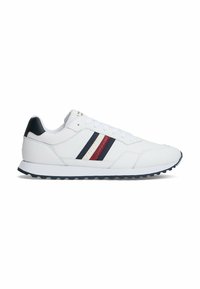 Witte sportieve schoenen met zwarte hakaccenten en drie horizontale strepen in rood, marineblauw en geperforeerde details. Getextureerde rubberen zool.
