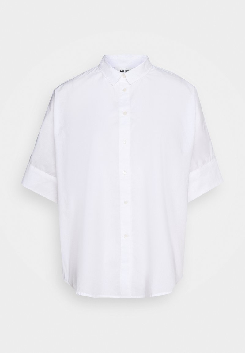 Chemise blanche à manches courtes avec col, fabriquée en tissu léger, présentant un devant à boutons et une coupe décontractée. Texture lisse sans motifs.