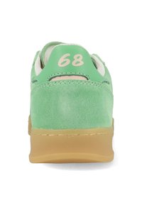 Grüne Wildleder-Sneaker mit runder Form, beiger Gummisohle und cremigen Akzenten; mit einem hellgrünen Absatz, auf dem die Zahl "68" gedruckt ist.