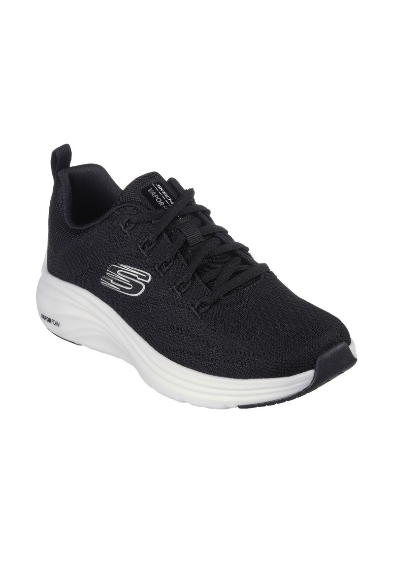 Zapatilla deportiva negra con parte superior de malla texturizada, que presenta cordones y una entresuela blanca. Logo en el lateral y un diseño de punta redondeada.