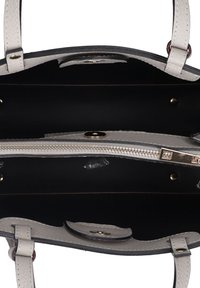 Borsa a tracolla bianca in pelle con finitura texturizzata. La vista interna mostra una fodera nera, una tasca con zip e dettagli in hardware dorato.