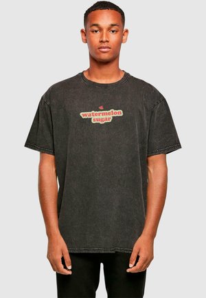 Sort denim T-shirt med et retro-inspireret "watermelon sugar" grafik i rød og grøn, med en løs pasform og rund halsudskæring.