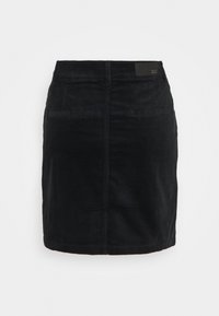 Gonna di velluto a coste nera con un design aderente, leggera texture, tasche anteriori e un'etichetta del marchio in vita. Lunghezza fino a metà coscia.
