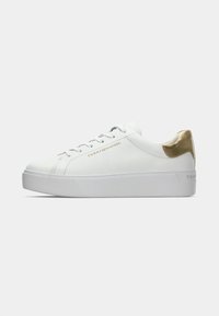 Baskets en cuir blanc avec un accent doré au talon, semelle plate et texture lisse. Présentent des lacets plats et un branding minimaliste sur le côté.