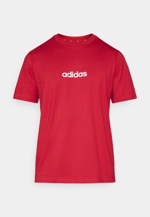 Červené bavlněné tričko s kulatým výstřihem a krátkými rukávy, s bílým logem "adidas" potištěným přes hrudník.