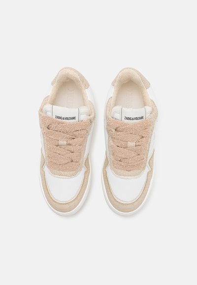 Sneakers featuring a white leather exterior with beige suede accents, textured laces, and a round toe design. Logo visible on the tongue.