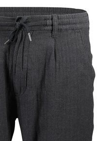 Pantalons à motif chevron gris foncé avec une taille élastique et un lien. Présente des plis et une texture lisse.