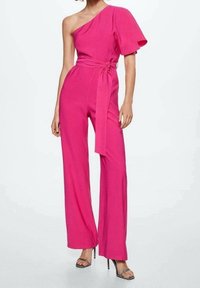 Combinaison fuchsia à une épaule avec un design à jambes larges, taille cintrée et tissu doux. Équipée d'un détail ceinturé à la taille.