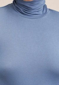 Blue turtleneck top made of smooth, stretchy fabric, featuring a fitted design and a high neck for coverage. No visible patterns or accents.