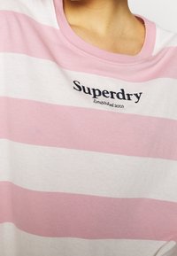 Pruhované tričko v růžové a bílé barvě, s kulatým výstřihem, krátkými rukávy a vyšívaným logem "Superdry" s detailem "Established 2003".