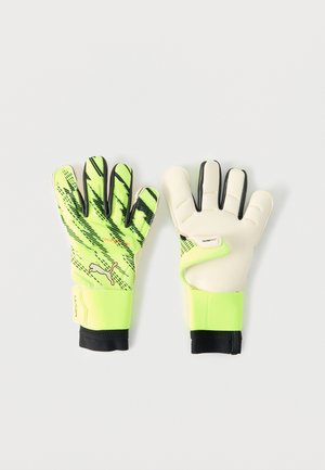 Zöld-fekete kapuskesztyűk texturált felülettel, párnázott fehér latex tenyérrel, állítható csuklópánttal és ergonómikus ujjkialakítással.