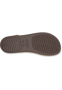 Suela de zapato de goma marrón con un patrón de textura, que presenta la marca "CROCS" y la designación de tamaño "W 7" grabada en la superficie.