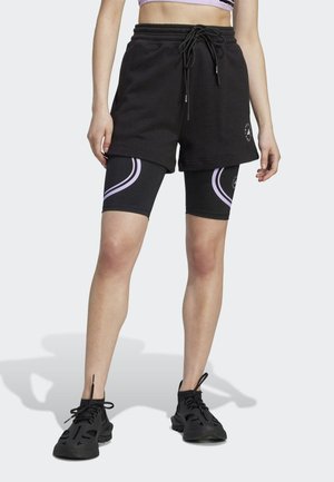 Black sweat shorts with an elastic waistband and drawstring, layered over black leggings featuring purple curved stripes. Black athletic shoes.