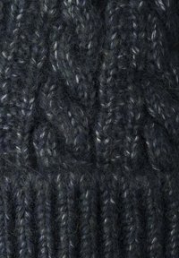 Tessuto lavorato a maglia grigio scuro con un motivo a treccia testurizzato. Presenta un filato morbido e peloso con sfumature di fibre più chiare intrecciate.
