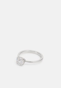 Bague en argent avec une pierre ronde et transparente entourée de petites accentuations, d'un bandeau lisse et poli, avec un design de sertissage classique.