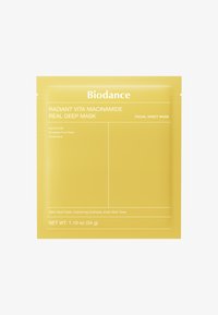 Żółty woreczek na maseczkę do twarzy z etykietą "Radiant Vita Niacinamide", z składnikami takimi jak niacynamid i woda z owoców ananasa.