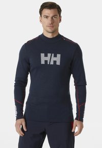 Marineblauwe langekous shirt met hoge kraag, met een witte "HH" logo, rode schouderaccenten en gestreepte details op de mouwen. Rekbare stof.
