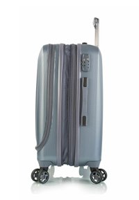 Hartschalenkoffer in metallic Lichtblau, mit strukturierter Oberfläche, glatten Doppelreißverschlüssen und vier drehbaren Rollen für eine einfache Manövrierfähigkeit.