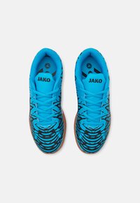 Zapatillas deportivas azules con un upper texturizado que presenta patrones en espiral negros. Diseñadas con cordones y una suela de goma para ofrecer tracción.