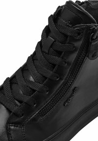 Baskets en cuir noir avec une surface texturée, un système de laçage complexe, une fermeture éclair et une semelle en caoutchouc plate.