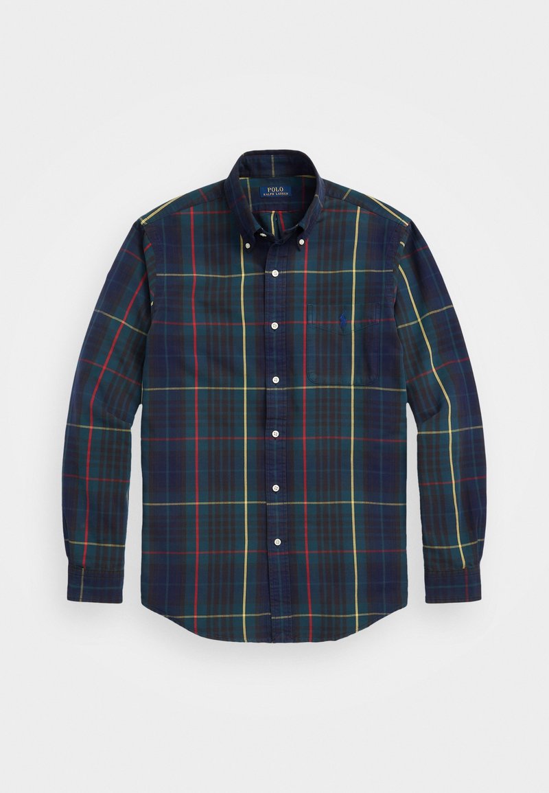 Långärmad skjorta med knappar i en marinblå rutigt mönster med gröna, röda och gula linjer. Inkluderar en bröstficka och krage.