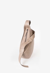 Beige Leder Schultertasche mit einem einzigen Tragegurt, Reißverschlussöffnung an der Seite, glatte Textur und abgerundetem, minimalistischem Design.