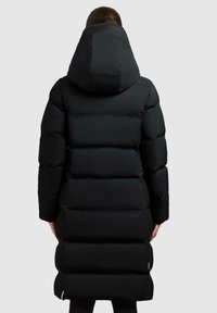 Zwarte pufferjas met een grote capuchon, voorzien van een doorgestikt ontwerp, lange mouwen en een knielange snit. Gladde, glanzende textuur en minimale details.
