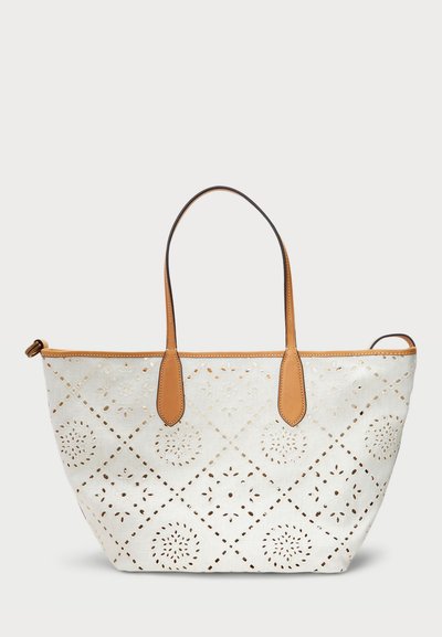 Borsa tote bianca con motivi floreali intagliati e manici in pelle marrone. La borsa ha una forma strutturata e cuciture dettagliate lungo i bordi.