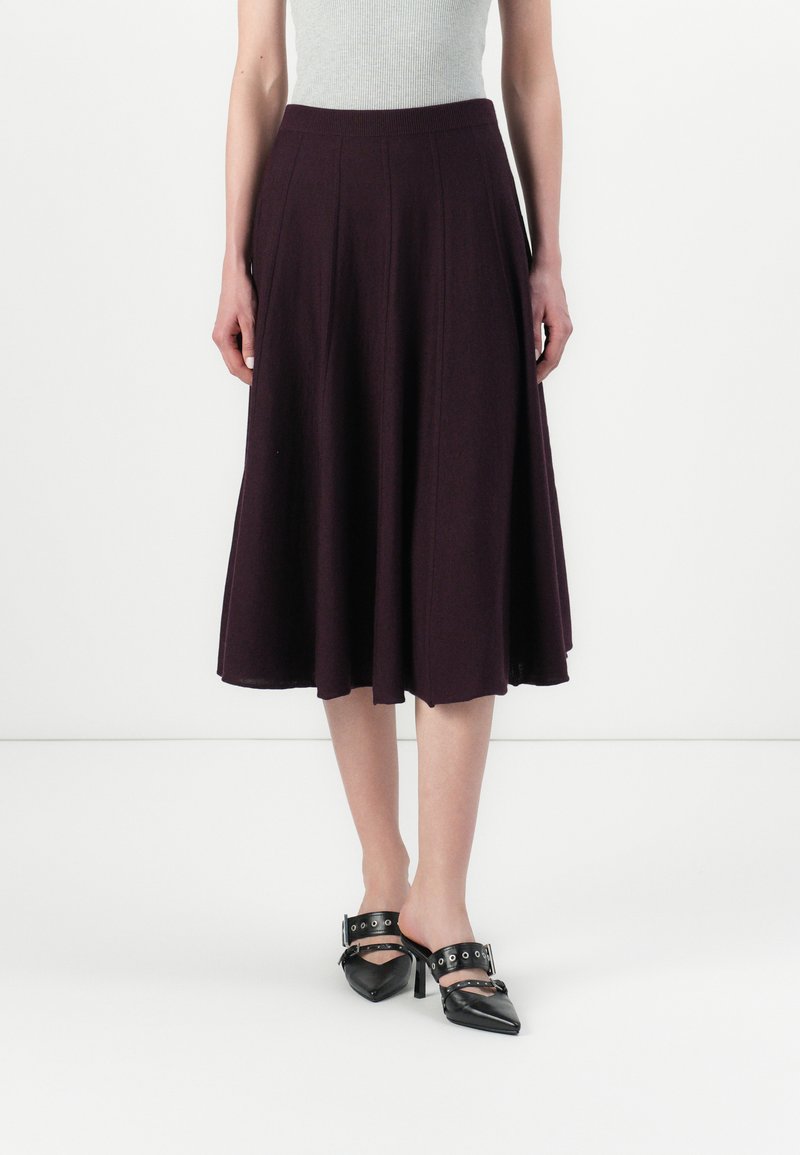 Une jupe évasée jusqu'au genou en tissu violet foncé avec une texture lisse, dotée d'une taille ajustée et de détails de couture verticaux.