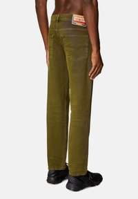 Jeans verde oliva a gamba dritta, con una leggera scoloritura, tasche posteriori e un'etichetta con il marchio vicino alla vita.