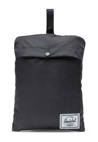Mochila plegable negra compacta hecha de nylon duradero, con una tapa superior, cierre de botón a presión y una etiqueta de marca.