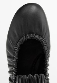 Schwarze Lederschuhe mit runder Zehenform und gerafftem oberen Rand, ausgestattet mit einer glatten Oberfläche und einem flexiblen Knöchel-Design.