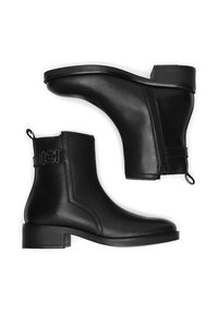 Fekete bőrből készült bokacsizma, lekerekített orral, oldalsó cipzárral és alacsony, téglalap alakú sarokkal. Díszítő pánttal és fém részletekkel rendelkezik.